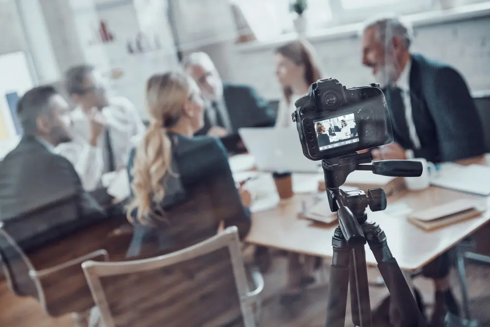 Trabajadores en oficina graban una reunión para editar un vídeo corporativo.